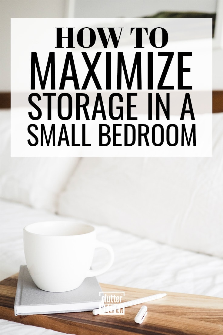 How to Maximize Storage in a Small Bedroom, A close-up of a bed with a wood headboard and two large pillows in a small bedroom with home storage problems. On the bed is a wood tray with a coffee cup stacked on top of a notebook. Next to the notebook is a small pen.
