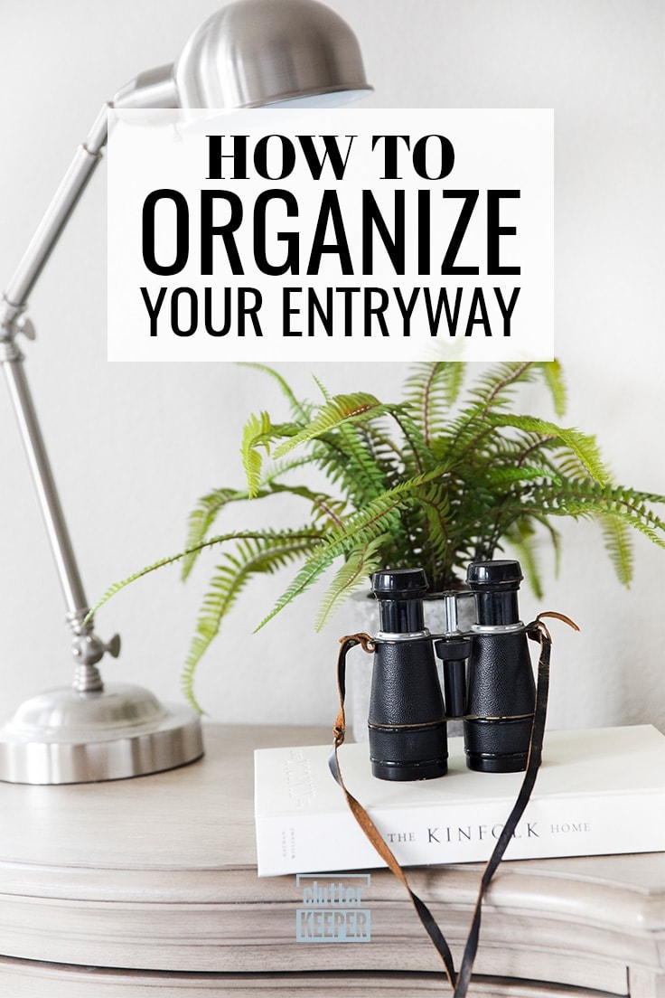How to Organize Your Entryway, an entryway table with a book, tall lamp, binoculars and a small plant