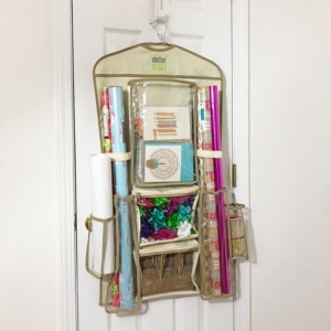Clutter Keeper® Hanging Gift Wrap Organizer filled with birthday cards, gift wrap and gift bags on a closet door.