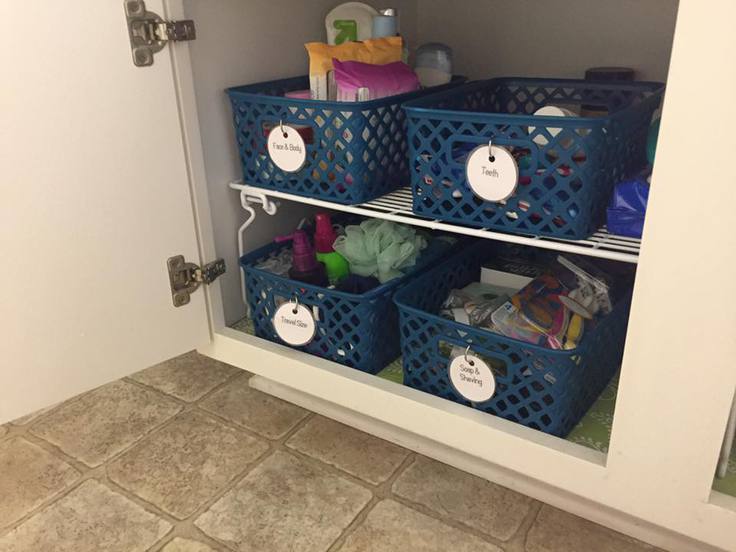 A bathroom cabinet with organized storage baskets