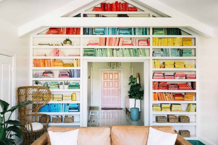 A home library with books arranged by color 
