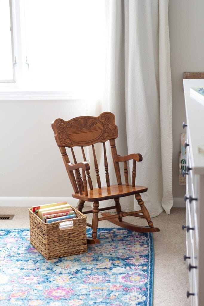 A child's rocking chair and a basket full of books 
